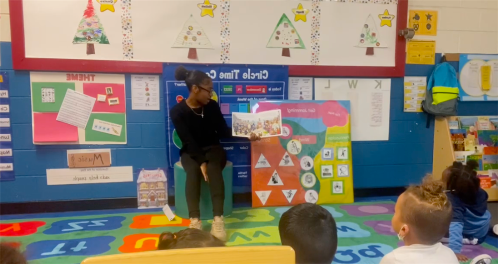 Young lady in front of classroom reading book Young lady in front of classroom reading book